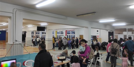 Powiększ grafikę: Uczestnicy Dnia Otwartego Szkoły Podstawowej nr 48 w Gdańsku. Korytarz szkolny. Wiele osób uczestniczy w różnych grach i zabawach.