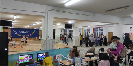 Powiększ grafikę: Uczestnicy Dnia Otwartego Szkoły Podstawowej nr 48 w Gdańsku. Korytarz szkolny. Wiele osób uczestniczy w różnych grach i zabawach.