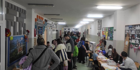 Powiększ grafikę: Uczestnicy Dnia Otwartego Szkoły Podstawowej nr 48 w Gdańsku. Korytarz szkolny. Wiele osób uczestniczy w różnych grach i zabawach.