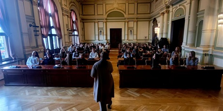 Powiększ grafikę: uczniowie w sali obrad