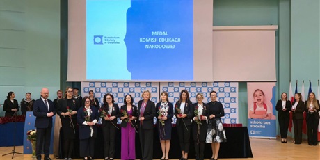 Powiększ grafikę: Nauczyciele stojący na scenie z otrzymanymi nagrodami. 