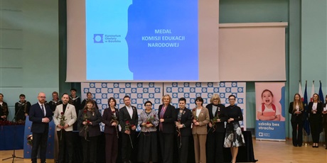 Powiększ grafikę: Nauczyciele stojący na scenie z otrzymanymi nagrodami. 