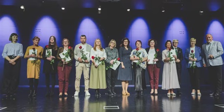 Powiększ grafikę: Nauczyciele stojący na scenie z otrzymanymi nagrodami. 