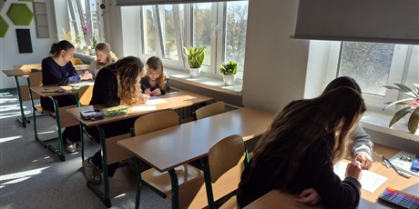 Powiększ grafikę: Uczniowie podczas konkursu. Siedzą w ławkach.